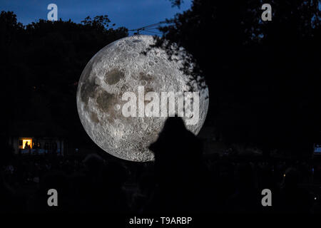 Brighton UK 17. Apr 2019 - Massen um Queens Park Teich in Brighton versammelten sich an diesem Abend das Brighton Festival Veranstaltung 'Museum der Mond' des Künstlers Luke Jerram, die zum 50. Jahrestag der Mondlandung gefeiert zu beobachten. Der Mond beleuchtet, über das Wochenende werden, begleitet von Musik des Komponisten Dan Jones. Foto: Simon Dack/Alamy leben Nachrichten Stockfoto