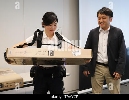 Tokio, Japan. 17 Mai, 2019. Japanese electronics Giant's Panasonic Roboter venture ATOUN Mitarbeiter ihre Servolenkung Anzug Powered mit neu Armteile unterstützt, was dabei hilft, einen schweren Gegenstand bei Panasonic des Büros in Tokio am Freitag, 17. Mai 2019, während ATOUN Präsident Hiromichi Fujimoto (R) Lächeln entwickelt Verschleiß zeigt. ATOUN entwickelt Powered Verschleiß im letzten Jahr des Benutzers zurück schwere Objekt für die Arbeiter der Lieferung, an Flughäfen, auf Baustellen und in der Landwirtschaft zu unterstützen. Credit: Yoshio Tsunoda/LBA/Alamy leben Nachrichten Stockfoto