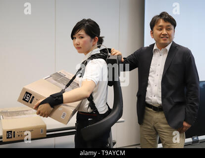 Tokio, Japan. 17 Mai, 2019. Japanese electronics Giant's Panasonic Roboter venture ATOUN Mitarbeiter ihre Servolenkung Anzug Powered mit neu Armteile unterstützt, was dabei hilft, einen schweren Gegenstand bei Panasonic des Büros in Tokio am Freitag, 17. Mai 2019, während ATOUN Präsident Hiromichi Fujimoto (R) Lächeln entwickelt Verschleiß zeigt. ATOUN entwickelt Powered Verschleiß im letzten Jahr des Benutzers zurück schwere Objekt für die Arbeiter der Lieferung, an Flughäfen, auf Baustellen und in der Landwirtschaft zu unterstützen. Credit: Yoshio Tsunoda/LBA/Alamy leben Nachrichten Stockfoto