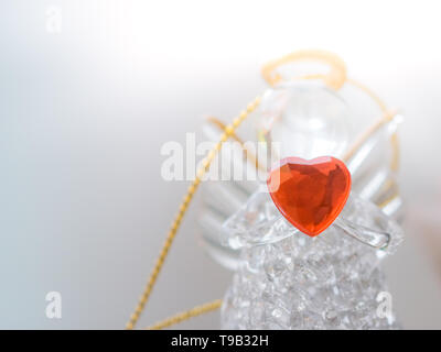 Glasengel-Statuette mit Herz Stockfoto