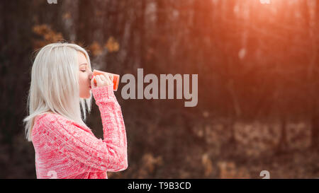 Junge Frau trinkt Tee aus dem Becher Stockfoto