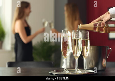 Kellner gießt Sekt in den Gläsern bei Party Stockfoto