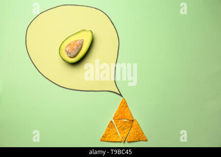 Kreative Komposition mit Mais Chips und Avocado auf farbigen Hintergrund Stockfoto