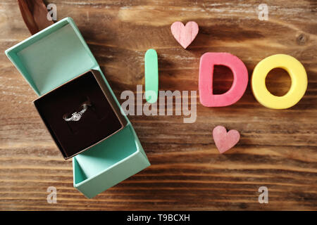 Box mit Verlobungsring und aufschrift ich auf hölzernen Tisch Stockfoto