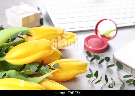 Gelbe Tulpen mit Eukalyptus Filialen auf Graue Tabelle Stockfoto