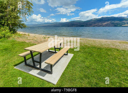 Picknickplatz mit Tisch und Bänken am Ufer des Okanagan See. Stockfoto