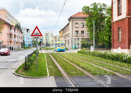 Bunte Straßenbahn fährt auf Straßenbahnschienen über grüne Wiese in Kosice (Slowakei) Stockfoto