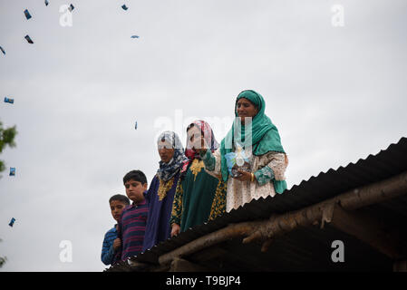 Ein Kaschmirischen Frau gesehen werfen Süßigkeiten während der trauerzug der getöteten JeM militante Naseer Ahmed Pandit während seiner Beerdigung in seiner Residenz in Pulwama, südlich von Srinagar. Drei Aktivisten, eine Armee und ein Zivilist in einer heftigen Schießerei, die im Bereich der Dalipora Pulwama Stadt im Süden Kaschmir am Donnerstag Morgen brach getötet wurden. Stockfoto