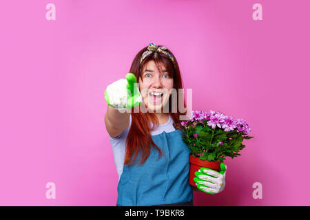 Foto von fröhliches Mädchen mit chrysantheme zeigende Hand zu übermitteln. Stockfoto