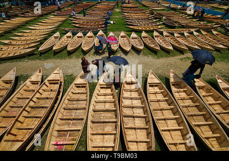 Hunderte von kleinen Booten aus Holz gesehen angezeigt zum Verkauf auf einen Markt wie Einheimischen für Monsun Saison vorzubereiten. Dutzende Herde von Meilen rund um ihre eigenen Boot auf einem Markt in Manikganj, Bangladesch zu kaufen, so wie für Überschwemmungen, die jederzeit zuschlagen können vorbereitet werden. Nach starken Regenfällen für Flussufer gemeinsam ist, zu platzen, Eintauchen in der Nähe Städte und Dörfer. Dies bedeutet, dass Autos und Busse überflüssig geworden und die Menschen sind gezwungen, mit dem Boot zu reisen. Jedes der Boote aus Holz und Rudern sind die Hand - von lokalen Handwerkern und können für so wenig wie 1700 Bangladeshi Taka - das Äquivalent von 20 US-Dollar gekauft werden. Stockfoto