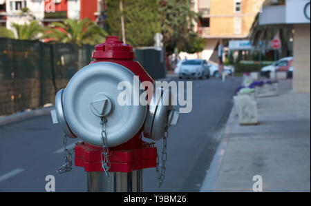 Kopf einer Straße Hydranten mit satiniertem Stahl caps gegen eine Stadt. Stockfoto