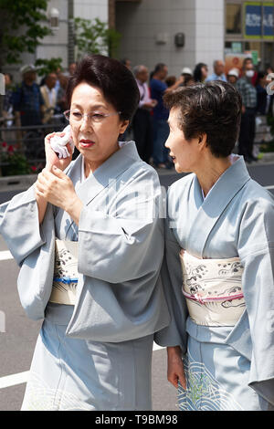 Japanische Frauen gekleidet im Kimono sprechen und Schweiß an einem heißen, sonnigen Tag wischen, während Sanja Matsuri in Asakusa, Tokyo, Japan. Stockfoto