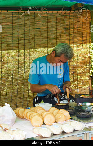 Ein reifer Mann macht und verkauft ein Japanischer süß, Karumeyaki (Wabe Toffee) mit traditionellen Werkzeugen, bei einem Essen an Sanja Matsuri, Asakusa, Tokyo. Stockfoto