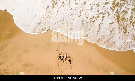 Vertikale Luftaufnahme der Gruppe junger Menschen Freunde den Sommer geniessen Urlaub am Strand mit grossen Welle kommen - schöne Outdoor natur Stockfoto