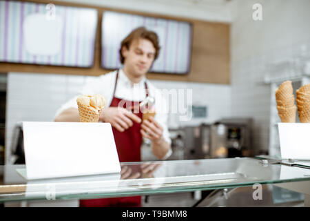 Eis auf den Zähler mit dem Verkäufer arbeiten auf dem Hintergrund im Shop Stockfoto