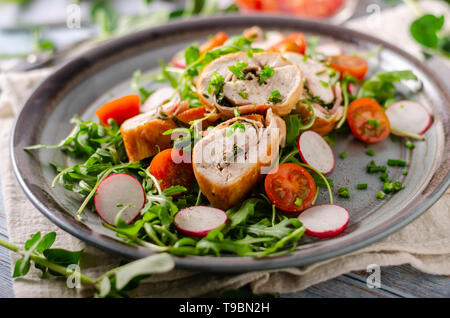 Chicken Roulade mit Kräuter und Schinken gefüllt, frischen Salat mit Radieschen Stockfoto