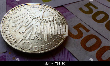 Nahaufnahme von einer westlichen zehn Deutsche Mark Münze, mit neuen 500-Euro-Banknoten im Hintergrund Stockfoto