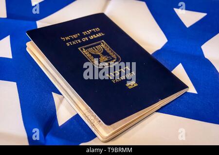 Ein blauer Reisepass des Staates Israel auf israelische Flagge im Hintergrund. Israel die israelische Staatsbürgerschaft Konzept, biometrische "arkon 'Pass illustrative Stockfoto