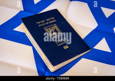 Ein blauer Reisepass des Staates Israel auf israelische Flagge im Hintergrund. Israel die israelische Staatsbürgerschaft Konzept, biometrische "arkon 'Pass illustrative Stockfoto