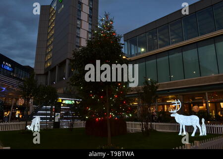 London/Großbritannien - 15. Dezember 2014: phosphoreszierende Hirsche gehen um Weihnachtsbaum in Westfield Stratford City Shopping Center installiert. Stockfoto