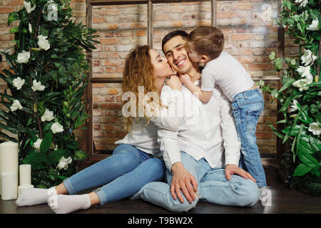 Frau und Kind küssen Mann. Happy Family im legere Kleidung Stockfoto