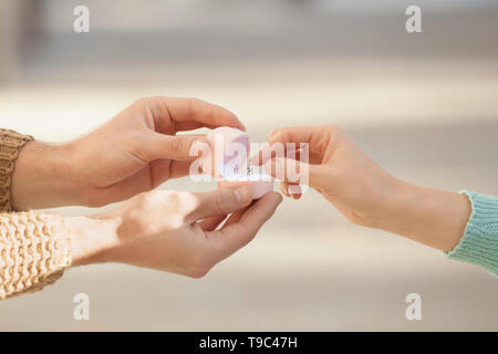 Junger Mann schlägt seine Geliebte im romantischen Datum im Freien Stockfoto