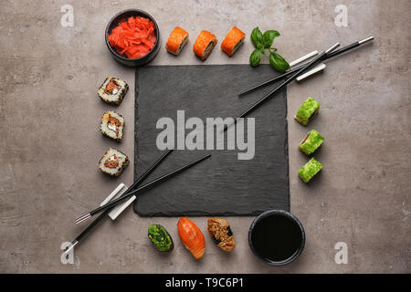 Schiefer Platte mit verschiedenen Sätzen von Sushi am grauen Tabelle Stockfoto