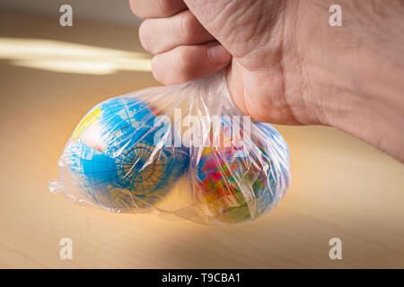 Die kleine Welt Globen in einen Plastikbeutel. Umwelt und globale Kunststoff Verschmutzung Metapher. Für den Tag der Erde geeignet, nachhaltige und Umwelt Stockfoto