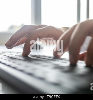 Detailansicht der männlichen Hand tippen auf Schwarz Computer Tastatur. Stockfoto