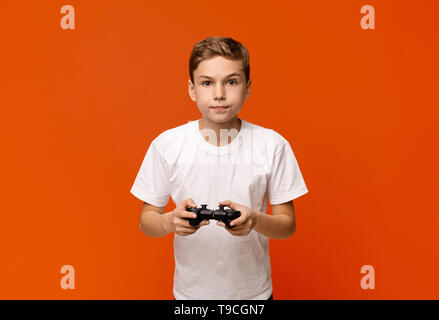 Konzentrierte Junge spielt Video Spiel mit Joystick Stockfoto