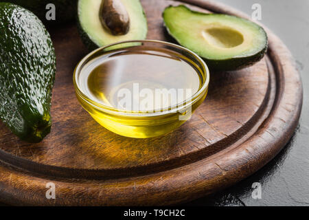 Öl in der Schüssel und frische Avocados Stockfoto