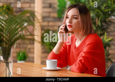 Junge Frau, die ihrem Freund im Cafe Stockfoto