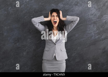 Emotionale Wut Geschäftsfrau Schreien über grauer Hintergrund Stockfoto