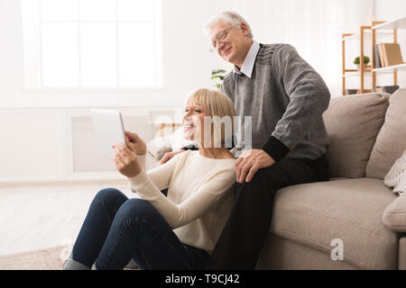 Ältere Paare mit digitalen Tablette im Wohnzimmer Stockfoto