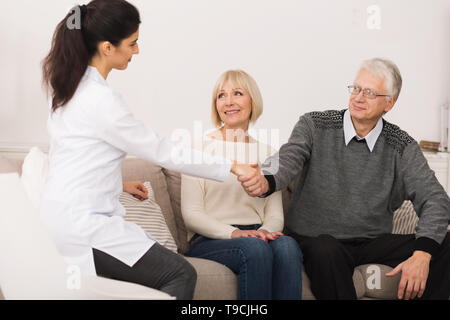 Reifes Paar einladende Krankenschwester während Home Besuch Stockfoto
