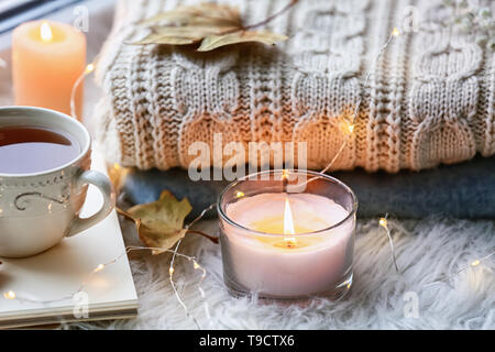 Schönen Herbst Komposition mit brennenden Kerzen und Tasse Tee auf Fensterbank Stockfoto