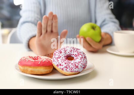 Frau weigert Donuts zu essen und "apple" statt. Diabetes Konzept Stockfoto