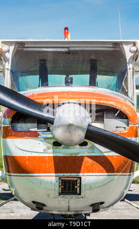 Kleine Light Utility Flugzeuge, tragen rote und weiße Farbe, Vordere Ansicht auf die Ebene mit Propeller, die Verkleidung und Kabine an einem sonnigen Tag. Stockfoto