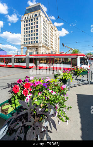 Samara, Russland - 9. Mai 2019: Stadtbild mit Blumen, rote Straßenbahn und den Bau von Lotte Hotel Samara im Sommer sonnigen Tag Stockfoto