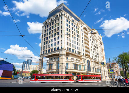 Samara, Russland - 9. Mai 2019: Stadtbild mit Blumen, rote Straßenbahn- und modernes Gebäude von Lotte Hotel Samara im Sommer sonnigen Tag Stockfoto