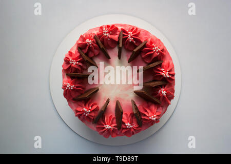 Cherry mousse Kuchen mit Sahne und Milch Schokolade Balken auf weissem Hintergrund aus einem hohen Winkel anzeigen isoliert Stockfoto