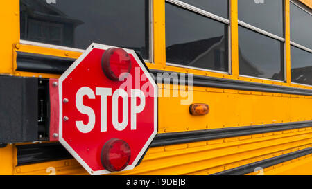 Klar Panorama Außenansicht eines gelben Schulbus mit einem roten Stoppschild und Blinkleuchten Stockfoto