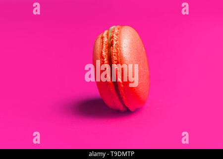 Süße orange Macarons auf rosa Hintergrund isoliert. Stockfoto