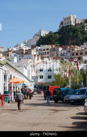 Unbekannte Menschen zu Fuß entlang der Hauptstraße von Moulay Idriss an einem sonnigen Tag. Moulay Idriss Zerhoun, Marokko. Stockfoto