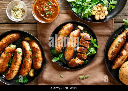 Gegrillte Würstchen über Holz- Hintergrund. Ansicht von oben, flach Stockfoto