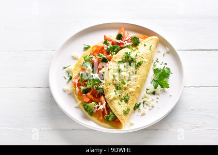 Omelett mit Tomaten, rote Paprika und Brokkoli auf hellem Holztisch. Gesunde Ernährung Essen zum Frühstück. Lecker morgen essen. Stockfoto