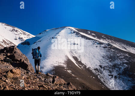 Ein Bergsteiger steht in schneebedeckten Berge. Stockfoto