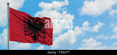 Albanien Flagge im Wind gegen Weiße bewölkt blauer Himmel. Diplomatie Konzept, internationale Beziehungen. Stockfoto