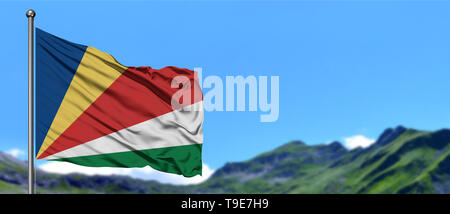 Seychellen Fahne winken in den blauen Himmel und grüne Felder bei Mountain Peak im Hintergrund. Thema Natur. Stockfoto