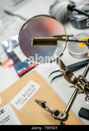 Experten der Polizei untersucht eine bullet Gap im wissenschaftlichen Labor mit Lupe Stockfoto